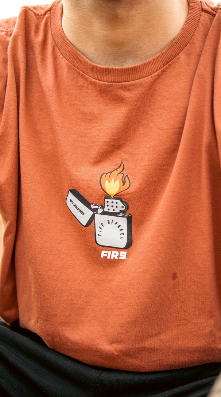 A casual fashion t-shirt featuring a flame graphic and lighter design.